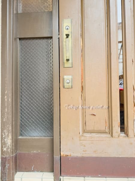 塗膜が劣化した木製玄関ドアの表面